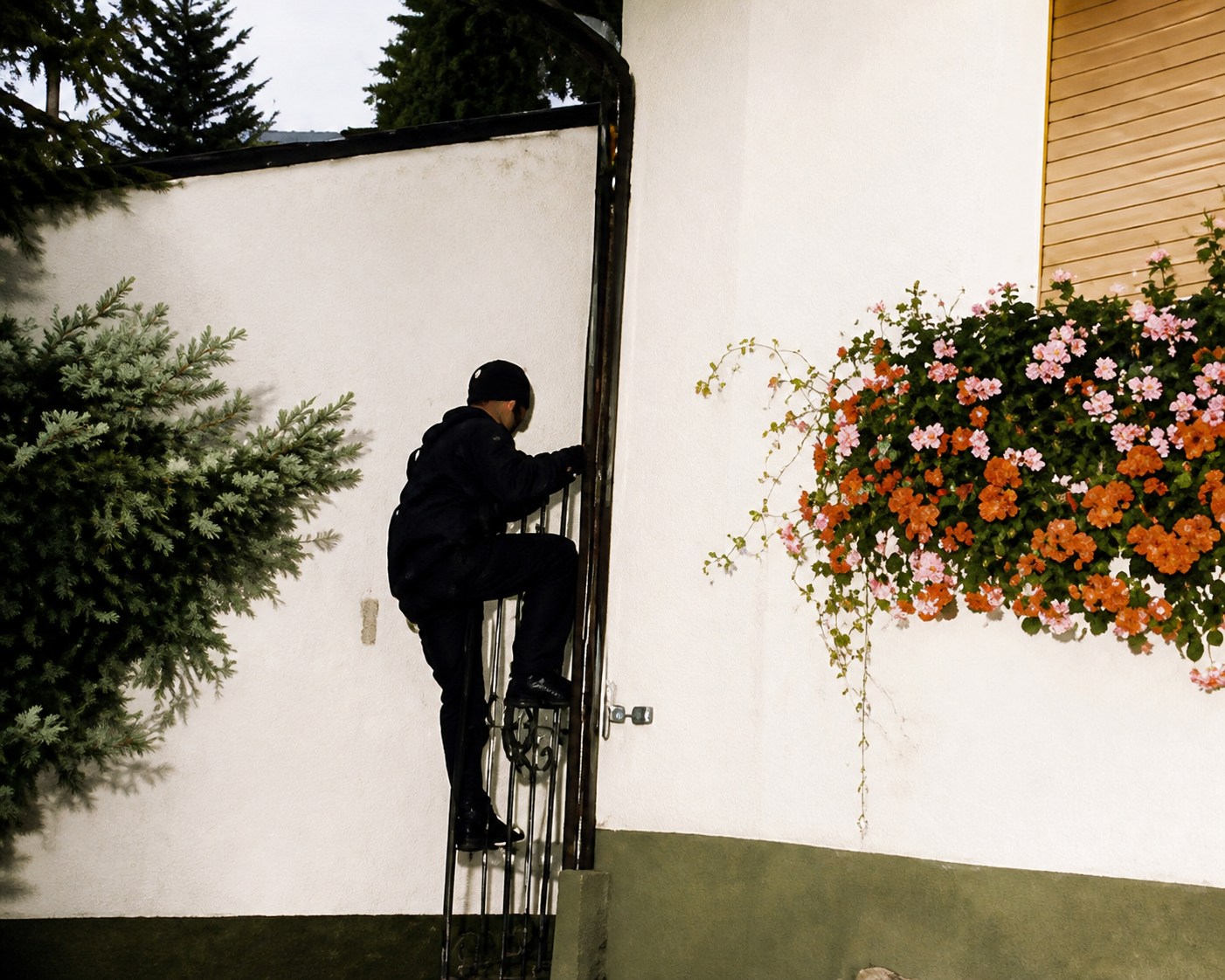 Mitarbeiter kontrolliert einen Hauseingang mit Blumenschmuck